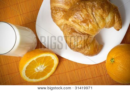 Hälsosam frukost med croissanter, orange och mjölk