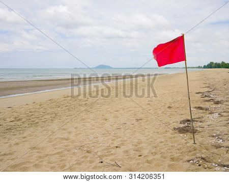 Red Flag Warning Sign On The Beach
