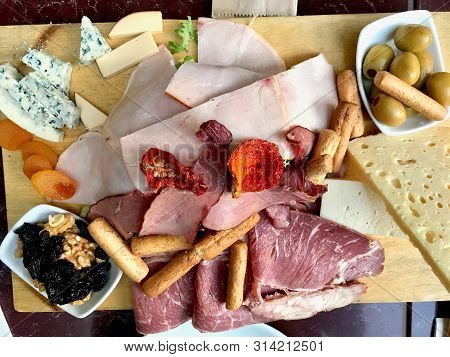 Red Wine And Assorted Cheese Plate, Smoked Beef, Ham, Salami, Green Olives With Fruit.