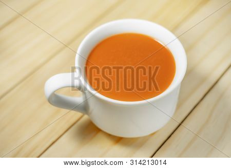 Hot Milk Tea In A White Cup On Wooden Background