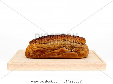A Homemade Plumcake Standing On A Wooden Board With A White Background