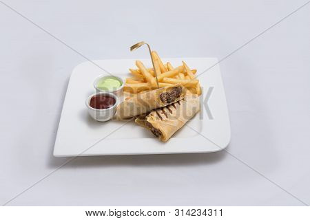 A Low Contrast Hero Shot Of A Beef Wrap Sandwich With Samurai & Alger Sauce And Fries On The Side, O
