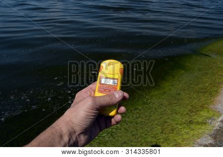 Geiger counter near storage pool near of hydroelectric station. After Chernobyl disaster - collection active sediments.The radiometer gives readings in micro-Sieverts. July 29, 2019.Kiev ,Ukraine