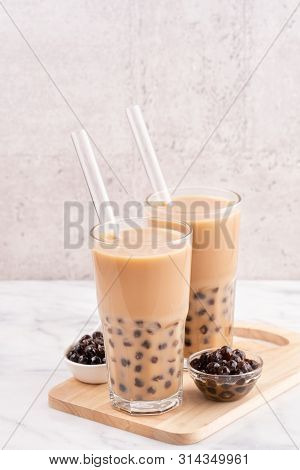 Tapioca Pearl Ball Bubble Milk Tea, Popular Taiwan Drink, In Drinking Glass With Straw On Marble Whi