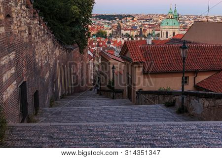 Pananorma View Over The Old Town Of Prague In The Evening. Steps Lead From The Prague Castle Down To