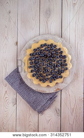 Homemade Cheesecake Decorated With Blueberry Over On White Wooden Background. Top View