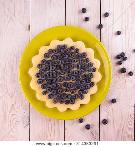Homemade Cheesecake Decorated With Blueberry Over On White Wooden Background. Top View