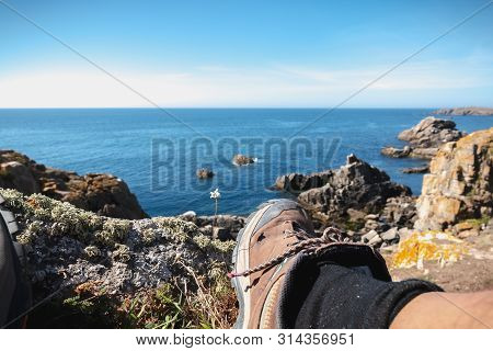 Walker Taking A Break On The Rocky Coast Of The Island Of Yeu, Vendee, France On A Fall Day