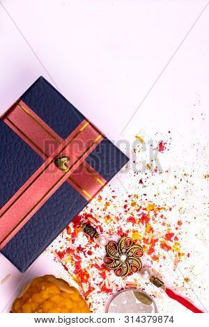 Indian Festival Of Brother And Sister - Rakhi And Sweet With Scattered Rice, Kumkum And Haldi On Whi