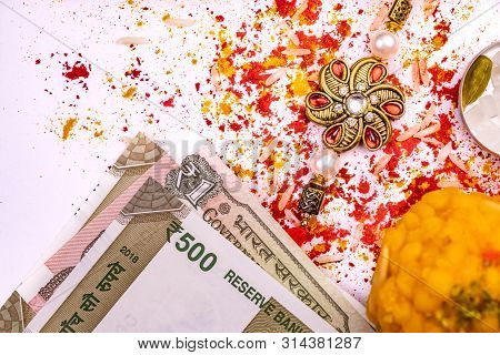 Indian Festival - Close View Of Scattered Rice Grains, Red Kumkum And Turmeric With Elegant Rakhi, S