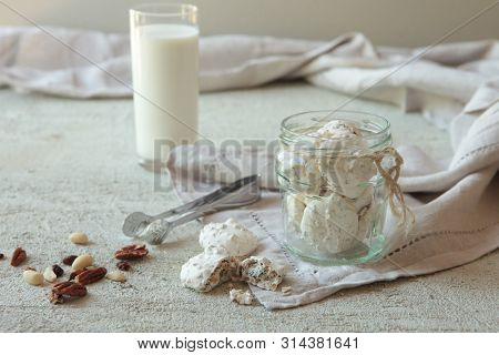 Traditional Beze Or Meringues With Nuts In A Glass Jar On Concrete Background. Copy Space. A Glass O