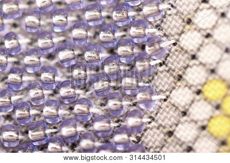 Macro Photo Of Purple Beadwork On The Canvas.