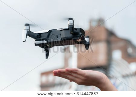 Close Up Of Drone Quadcopter Inflight. Cityscape Background.