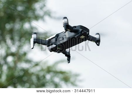 Close Up Of Drone Quadcopter Inflight. Cityscape Background.