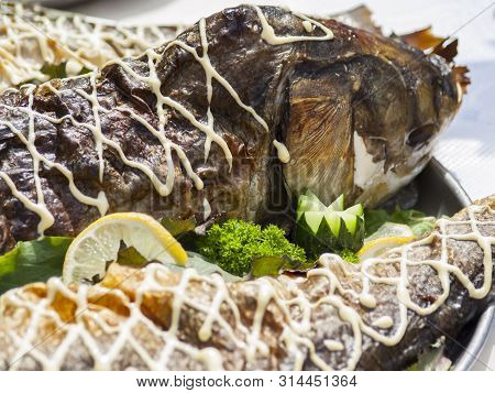 Stuffed Fish On A Tray With Greens And Lemon