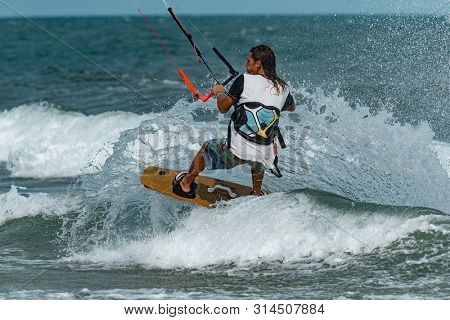 Kitesurfing on the waves of the sea in Mui Ne beach, Phan Thiet, Binh Thuan, Vietnam. Kitesurfing, Kiteboarding action photos Kitesurfer In action
