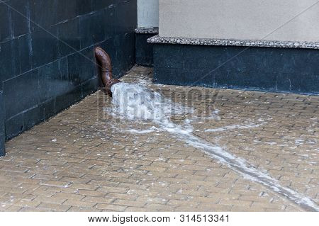 Heavy Rain Outdoors. Metal Drain Is Filling With Water. Gutter Pipes Flooding. Flood In The City