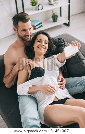 Handsome Man And Sexy Woman In Shirt And Bra Smiling And Taking Selfie
