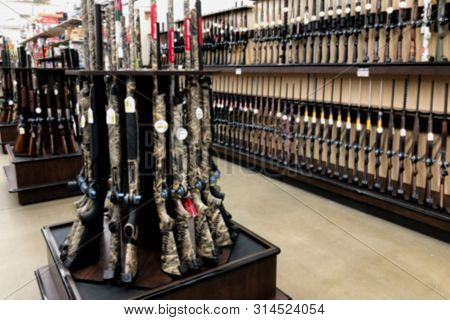 Blurred Photo Of Shot Gun Rifle Display In Hunting Department Of Retail Store.
