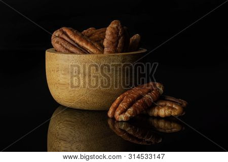 Lot Of Whole Fresh Brown Pecan Nut Half Two Is Near In A Wooden Bowl Isolated On Black Glass