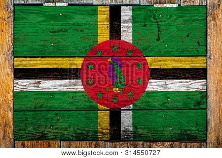 National Flag Of Dominica On A Wooden Wall Background.the Concept Of National Pride And Symbol Of Th