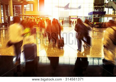 People With Traveling Luggage Walking In Airport Terminal