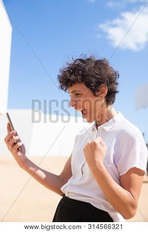 Excited Woman Holding Cell Phone Outdoor. Emotional Middle Aged Businesswoman Using Smartphone Benar