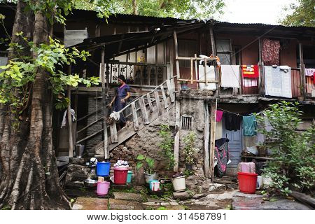 Pune, India, March 2012, Woman Climbing Down Wooden Staircase In Old Chawl.