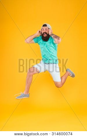 Happy Music. Happy Hipster Jumping On Music On Yellow Background. Bearded Man Enjoying Song Playing 