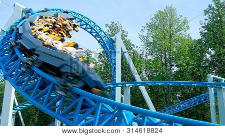 Joyful People Drive Along Roller Coaster Rails Upsidedown