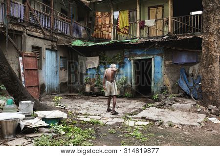 Pune, India, July 2012, Old Man Walking Outside Old Building In Wadas