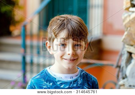 Portrait Of Lovely Gorgeos School Kid Boy Sitting Infront Of House. Happy Healthy Boy On Stairs By H