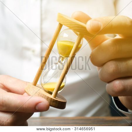 Businessman Holds Clock In Hands. Concept Of Saving Time And Money. Time Management. Planning Work. 
