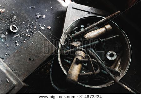 Many Different Metal Parts Are Rotated On The Worktable. Old Workshop. Mess In The Garage. Industry