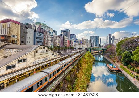 Trains pass by the Kanda River in the Ochanomizu district of Tokyo, Japan.