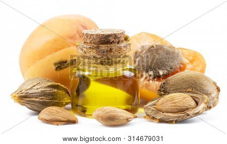 Apricot kernel oil and apricot kernels isolated on the white background.