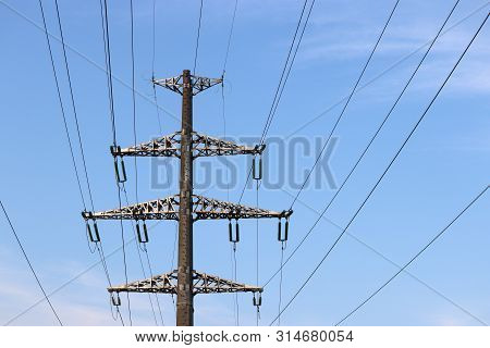 High Voltage Tower With Electrical Wires On Blue Sky With Clouds. Power Line Support, Electricity Tr