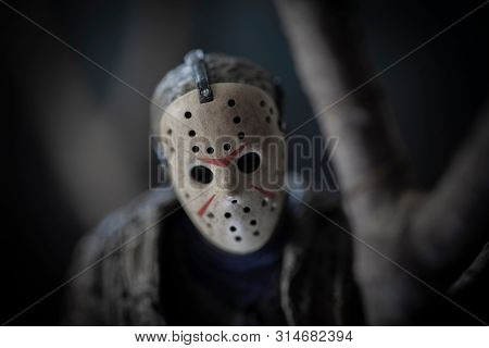 JULY 30 2019: Friday the 13th slasher Jason Voorhees lurking behind a tree in the woods - NECA Ultimate Jason action figure