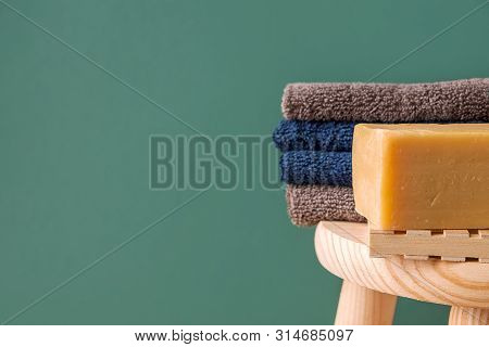 Folded Cotton Terry Towels Washcloth Handmade Artisan Olive Oil Soap On Wooden Chair In Bathroom On 