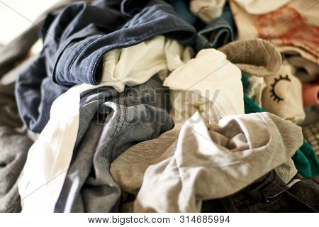 Close Up On A Big Pile Of Clothes And Accessories Thrown On The Ground. Untidy Cluttered