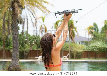 Female Launches A Drone For Flight, With Which You Can Take Photos And Videos, Near The Swimming Poo