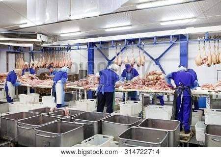 Cutting Meat In Slaughterhouse. Butcher Cutting Pork At The Meat Manufacturing.