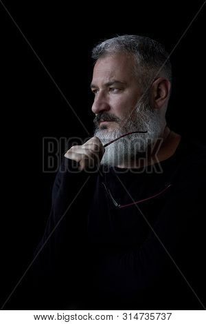 Artistic Portrait Of A Brutal Gray Haired Man With A Beard And Glasses On A Black Background, Select