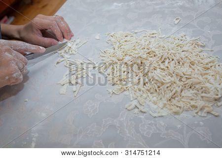 Cutting Long Dough Stripe For Cooking Pasta. Homemade Food Preparation Concept. Closeup Of Process O