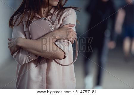Cropped View Of Scared Woman Holding Purse In Underpass