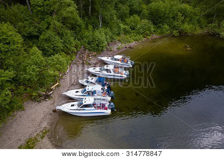 Five Boats Standing On The Pier On The Teletskoe Lake In The Altai Mountains Near The Local Landmark