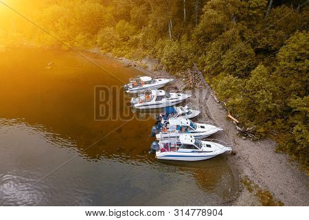 Five Boats Standing On The Pier On The Teletskoe Lake In The Altai Mountains Near The Local Landmark