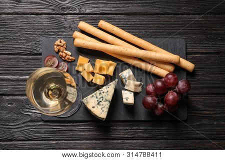 Flat Lay Composition With Different Types Of Delicious Cheese On Slate Board