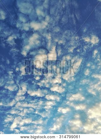 Colorful Blue Sky With Scattered Clouds Bath With Warm Yellow Light. Cloud Caught By Hot Tone From M