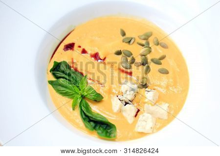 Cheese Soup Closeup In A White Plate On A White Background.